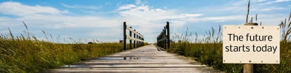 A wooden bridge with a sign that says "The Future Starts Today"